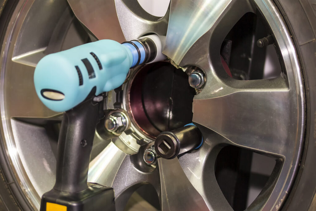 Close up electric wrench tool or instrument for assembly or un install car wheel at garage or workshop