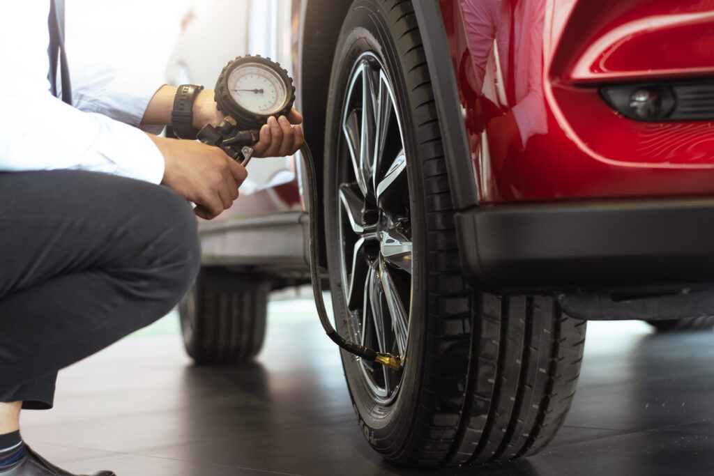 Asian man car inspection Measure quantity Inflated Rubber tires car.Close up hand holding machine Inflated pressure gauge for car tyre pressure measurement for automotive, automobile image