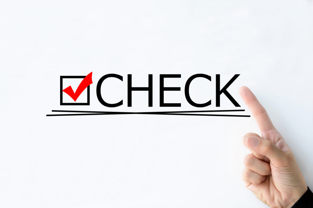Business man's hand pointing at "CHECK" word on white board
