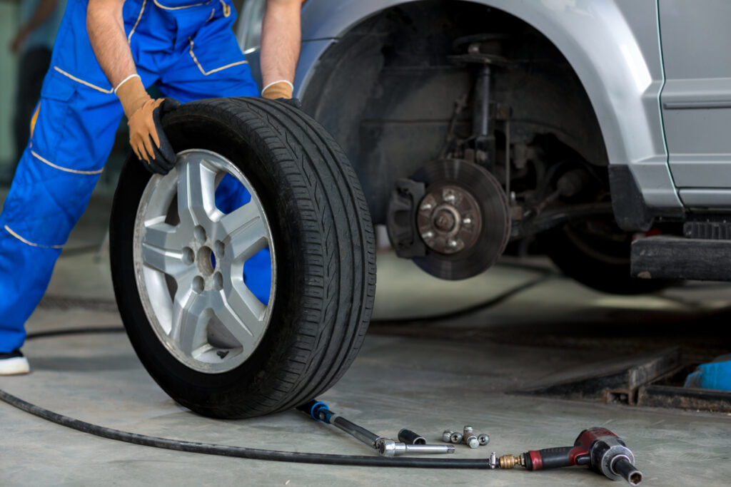 mechanic changing a wheel of a modern car in a workshop