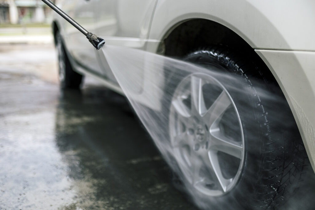 Man washes the car with a hose