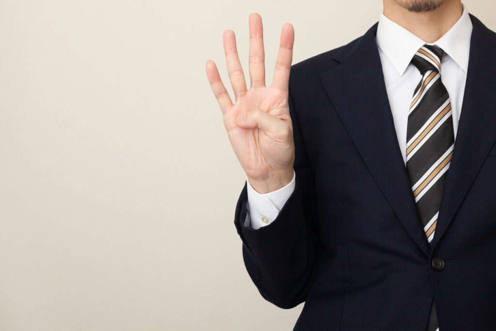 A man in a suit with four fingers, white background