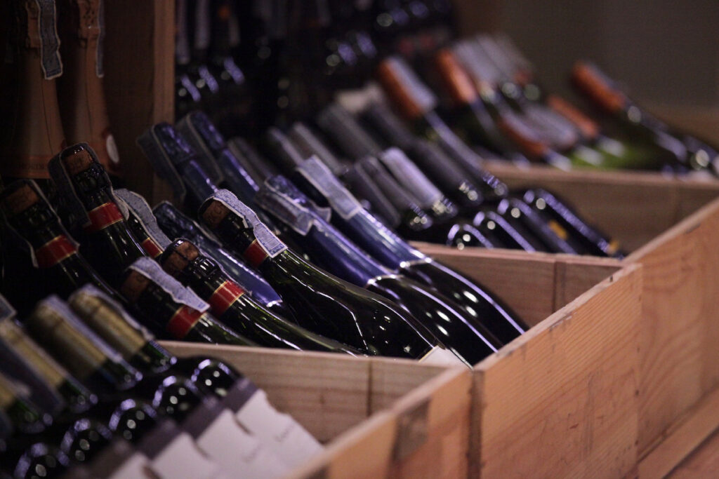 a lot of wine bottles put in crates for classified to display in a wine retail shop