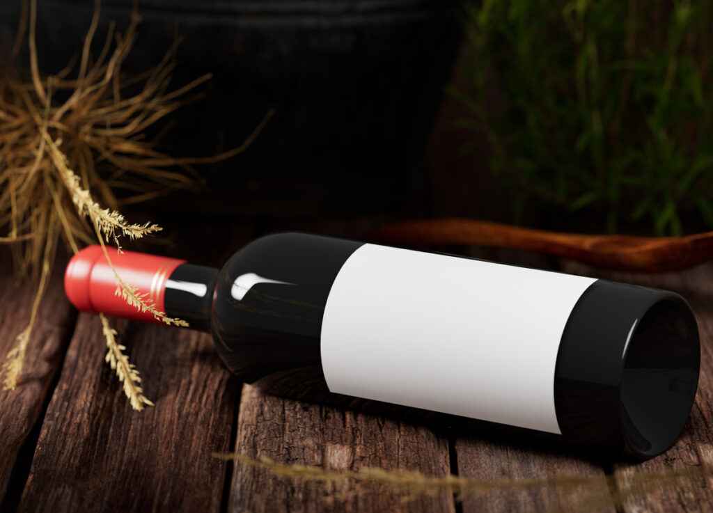 Wine bottle with blank white label on wood rustic background