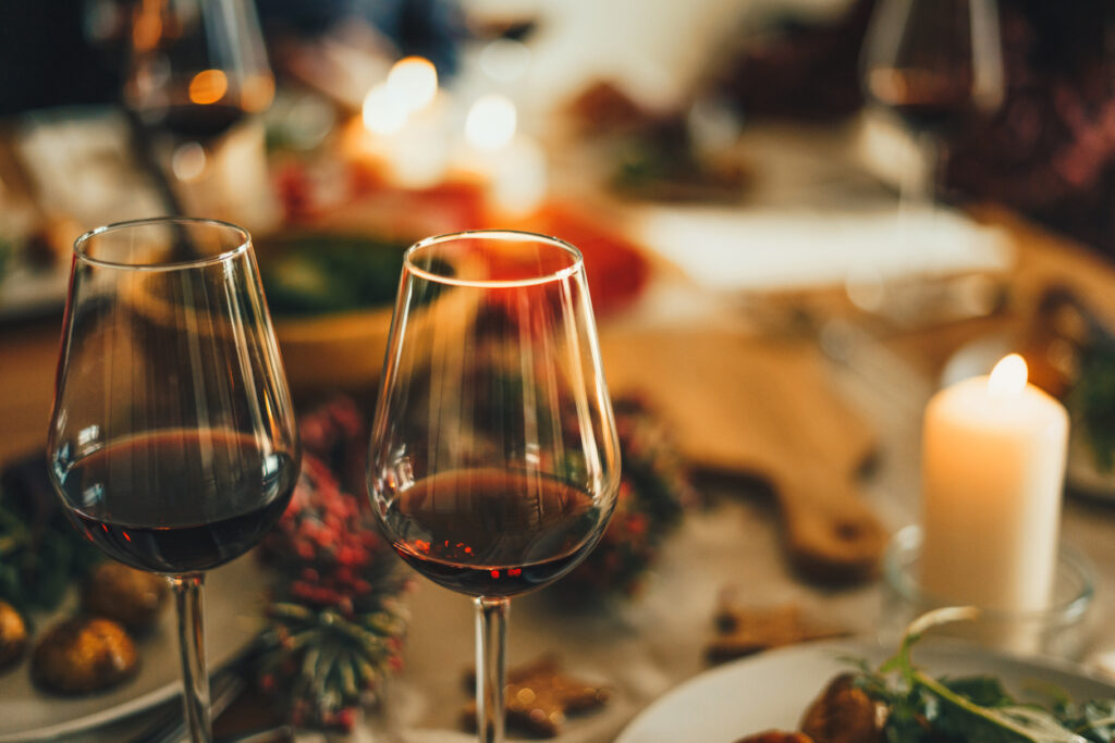 Close up shot of red wine glasses at Christmas dinner table.