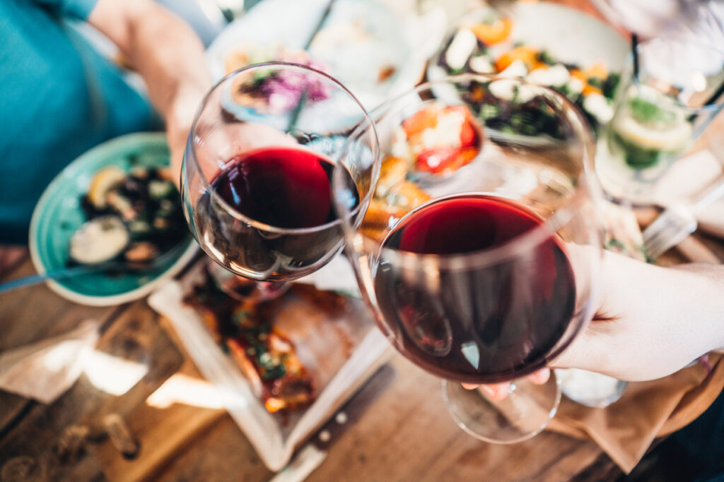 Close up of a friends toasting with red wine at restaurant