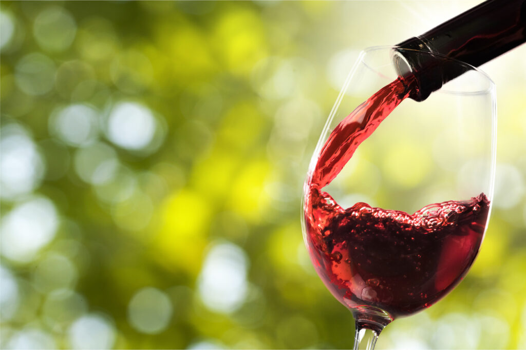 Red wine and glass on background